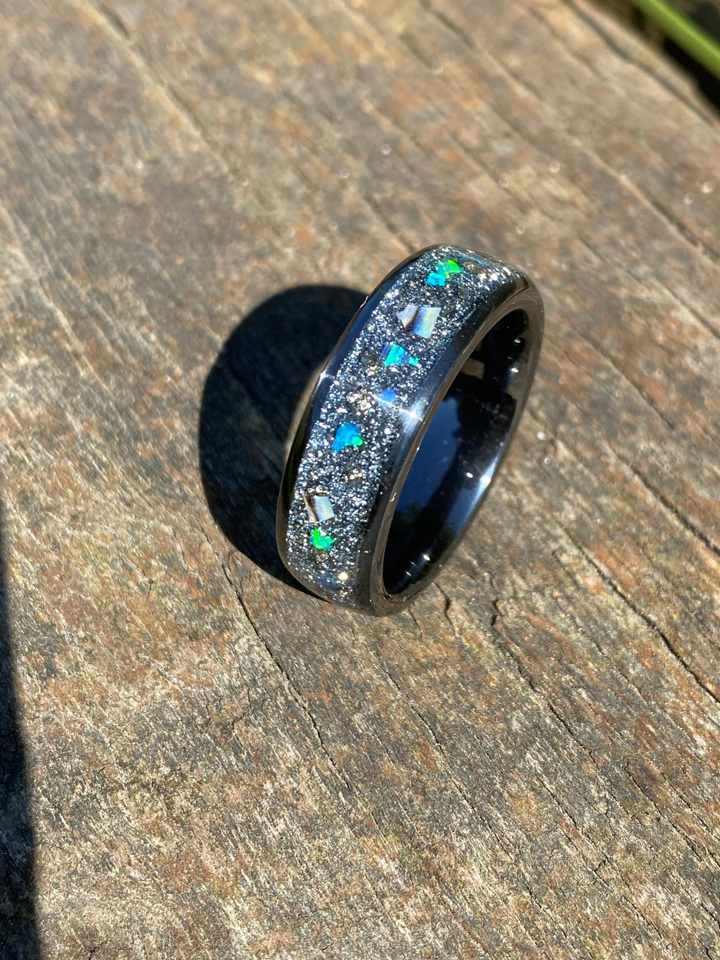 Space ring on black ceramic band inlayed with glitter opal pyrite